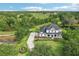 Aerial shot of home with a long driveway, lush greenery, and a tranquil pond nearby at 19803 Prince Benjamin Dr, Lutz, FL 33549