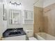 Bathroom featuring tub-shower combination, dark marble vanity, and bright vanity lighting at 19803 Prince Benjamin Dr, Lutz, FL 33549