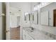 Bathroom with granite vanity, mirrored cabinets, and an open doorway at 19803 Prince Benjamin Dr, Lutz, FL 33549