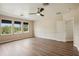 Bedroom with neutral walls, laminate wood flooring, three windows, and a ceiling fan at 19803 Prince Benjamin Dr, Lutz, FL 33549