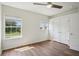 Bright bedroom with wood floors, two windows, ceiling fan, and double door closet at 19803 Prince Benjamin Dr, Lutz, FL 33549