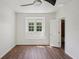 Bright bedroom with wood flooring, open doorway, and a window with green views at 19803 Prince Benjamin Dr, Lutz, FL 33549