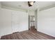 Bedroom with wood floors, neutral walls, a ceiling fan, and an entry to the hallway at 19803 Prince Benjamin Dr, Lutz, FL 33549