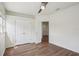 Spacious bedroom with hardwood floors, bright white walls, a ceiling fan, and double-door closet at 19803 Prince Benjamin Dr, Lutz, FL 33549