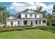 Charming two-story home with a welcoming wrap-around porch and beautifully landscaped front yard at 19803 Prince Benjamin Dr, Lutz, FL 33549