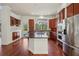Gourmet kitchen featuring granite countertops, a stylish island, stainless steel appliances, and hardwood floors at 19803 Prince Benjamin Dr, Lutz, FL 33549
