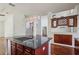 Kitchen island with granite countertop and cooktop with dark wood cabinetry and stainless steel appliances at 19803 Prince Benjamin Dr, Lutz, FL 33549