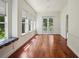Bright living room featuring hardwood floors, multiple windows, and french doors leading to the exterior at 19803 Prince Benjamin Dr, Lutz, FL 33549