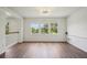Bright living room with laminate floors, white walls, and three windows offering natural light at 19803 Prince Benjamin Dr, Lutz, FL 33549