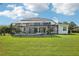 Expansive backyard featuring a screened-in pool and spa, with a well-maintained lawn and inviting outdoor space at 19803 Prince Benjamin Dr, Lutz, FL 33549