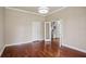 Open room with gleaming hardwood floors leading to an open staircase and neutral colored walls at 19803 Prince Benjamin Dr, Lutz, FL 33549