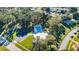 Aerial view of community pool, clubhouse, and parking area amid lush trees at 2212 Portside Psge, Palm Harbor, FL 34685