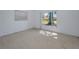 A clean bedroom with carpet flooring, a window, and neutral wall paint at 2212 Portside Psge, Palm Harbor, FL 34685