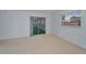Bright bedroom with sliding door access to a carpeted sunroom and natural light at 2212 Portside Psge, Palm Harbor, FL 34685
