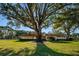 Well-maintained exterior of a community building with a manicured lawn and mature trees offering a peaceful setting at 2212 Portside Psge, Palm Harbor, FL 34685