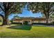 Well-maintained exterior of a community building with a manicured lawn and mature trees offering a peaceful setting at 2212 Portside Psge, Palm Harbor, FL 34685