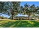 Spacious building surrounded by large trees, a manicured lawn, and an American flag at 2212 Portside Psge, Palm Harbor, FL 34685