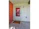 The front door is on a covered porch next to a brick wall with a welcome mat in front of the door at 2212 Portside Psge, Palm Harbor, FL 34685