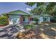 Charming single-story home with light green siding, red brick accents, and a well-manicured lawn at 2212 Portside Psge, Palm Harbor, FL 34685