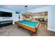 Spacious game room featuring a pool table, piano, TV and an open floorplan to a dining and kitchen area at 2212 Portside Psge, Palm Harbor, FL 34685