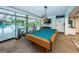 Relaxing game room with large windows, pool table, a piano, and barstool seating overlooking the pool area at 2212 Portside Psge, Palm Harbor, FL 34685