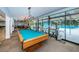 Brightly lit game room complete with pool table, barstool seating and views overlooking the community pool at 2212 Portside Psge, Palm Harbor, FL 34685