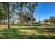 The property offers lush green space shaded by tall trees at 2212 Portside Psge, Palm Harbor, FL 34685