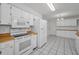 Bright kitchen features white appliances, cabinets, wood trim and tile flooring at 2212 Portside Psge, Palm Harbor, FL 34685