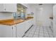 Well-lit kitchen featuring white appliances, wood countertops, and tile flooring at 2212 Portside Psge, Palm Harbor, FL 34685