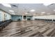 Bright meeting room with long wood-look floors, modern lighting, and a cozy fireplace for gatherings at 2212 Portside Psge, Palm Harbor, FL 34685