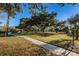 Peaceful community grounds with grassy lawn and shaded pathway leading to community amenities on a beautiful sunny day at 2212 Portside Psge, Palm Harbor, FL 34685