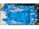 Overhead view of a clear blue community pool with lounge seating at 2212 Portside Psge, Palm Harbor, FL 34685