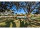 Relaxing community pool area with lounge chairs surrounded by trees on a sunny day offers an escape from the Florida heat at 2212 Portside Psge, Palm Harbor, FL 34685