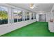 Enclosed sun room has bright green carpet and slider windows at 2212 Portside Psge, Palm Harbor, FL 34685
