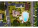 An aerial view of the pool and clubhouse area surrounded by lush greenery, parking, and residential buildings at 255 114Th N Ave # 4, St Petersburg, FL 33716