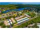 An aerial view of the community featuring lush landscaping, a pond, and a community pool and tennis courts at 255 114Th N Ave # 4, St Petersburg, FL 33716