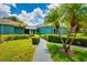 A well-maintained condominium building with a landscaped pathway leading to the entrance, enhanced by swaying palm trees at 255 114Th N Ave # 4, St Petersburg, FL 33716