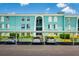 A view of the aqua building with a parking spot for each unit, and lush greenery surrounding the building at 255 114Th N Ave # 4, St Petersburg, FL 33716