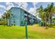 Turquoise condo building with balconies surrounded by manicured grounds and palm trees at 255 114Th N Ave # 4, St Petersburg, FL 33716