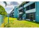 Three story condo building with stairs, balconies, and green space at 255 114Th N Ave # 4, St Petersburg, FL 33716