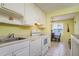 A view of the kitchen with white cabinets, countertops and appliances with a dining room in the background at 255 114Th N Ave # 4, St Petersburg, FL 33716