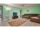 A view of the living room with a brown sectional sofa, a ceiling fan, tile floors and green walls at 255 114Th N Ave # 4, St Petersburg, FL 33716