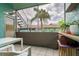A view of the outdoor patio with tiled floors, and a view of a palm tree and greenery at 255 114Th N Ave # 4, St Petersburg, FL 33716