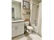 This bathroom is complete with a granite double vanity, storage shelves, and a shower-tub combo at 2717 Chestnut Creek Pl, Brandon, FL 33510