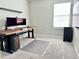This bedroom has carpeted floors, a desk with monitor, and a large window for natural light at 2717 Chestnut Creek Pl, Brandon, FL 33510