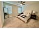 Neutral bedroom features a ceiling fan, bedside tables, a large mirror, and carpeted floors at 2717 Chestnut Creek Pl, Brandon, FL 33510