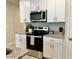 Well-equipped kitchen with stainless steel appliances, granite countertops, and sleek white cabinets at 2717 Chestnut Creek Pl, Brandon, FL 33510