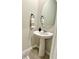 Elegant powder room with a pedestal sink, oval mirror, and neutral decor at 2717 Chestnut Creek Pl, Brandon, FL 33510