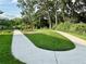Well-maintained walking path featuring manicured landscaping and mature trees, perfect for a leisurely stroll at 2717 Chestnut Creek Pl, Brandon, FL 33510