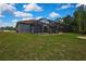 Spacious backyard with a screened pool enclosure, blending relaxation with outdoor enjoyment and natural views at 27338 Elkwood Cir, Wesley Chapel, FL 33544